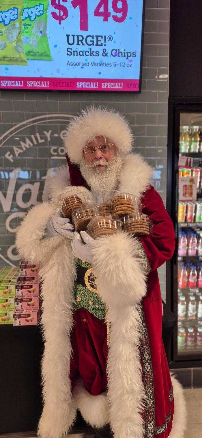 Santa with an armful of cookie packages at a local shop